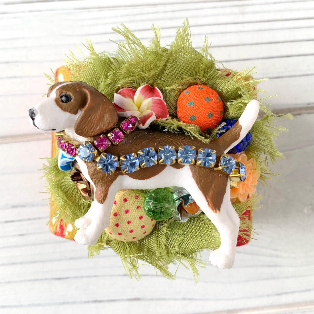 Dog bracelet with brown and white toy beagle figurine adorned with rhinestones, fabric buttons and flowers on a cuff bracelet.