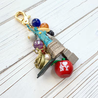 New York City bag charm . New York City keychain with colorful beads and statue of liberty charm, Prometheus charm, and Chrysler Building charm.