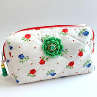 Red and blue flowers on white cotton fabric quilted zipper pouch embellished with a green crochet flower with a vintage earring center. Quilted makeup bag. Cute makeup bags with zipper. Gifts for mom.