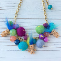 Troll dolls necklace with miniature trolls dolls with crazy hair and a mix of felt balls and beads on a gold chain.
