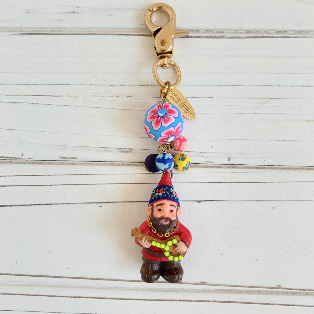 Miniature toy garden gnome bag charm to decorate a handbag or purse. Beaded bag charm with embellished garden gnome with beard playing a banjo.
