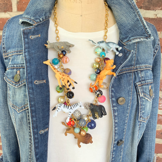 Long Safari animal necklace filled with miniature safari animal charms and colorful beads on gold chain.