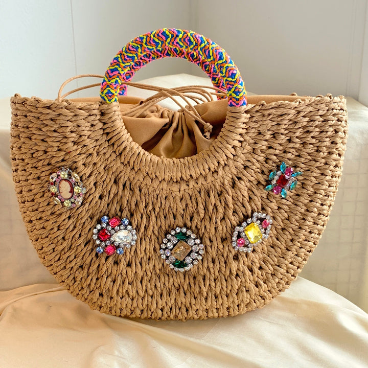 Half moon straw handbag - top handle straw handbag embellished with rhinestone brooches and a round top handle wrapped in fabric trim.
