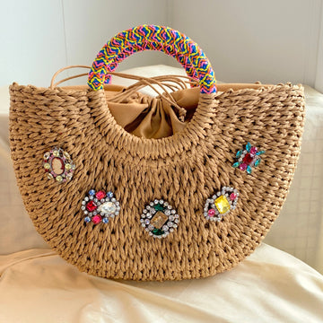 Half moon straw handbag - top handle straw handbag embellished with rhinestone brooches and a round top handle wrapped in fabric trim.