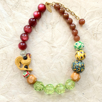 Crazy necklace with rooster and large beads. Big beaded necklace in green and brown tones with rooster figurine. Lenora Dame jewelry.