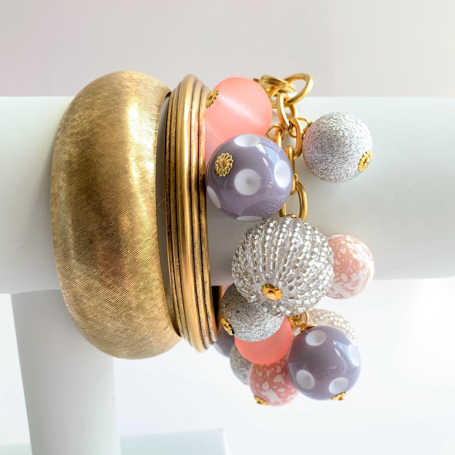 Lenora Dame charm bracelet stacked with two gold bangle bracelets for bracelet styling inspiration.