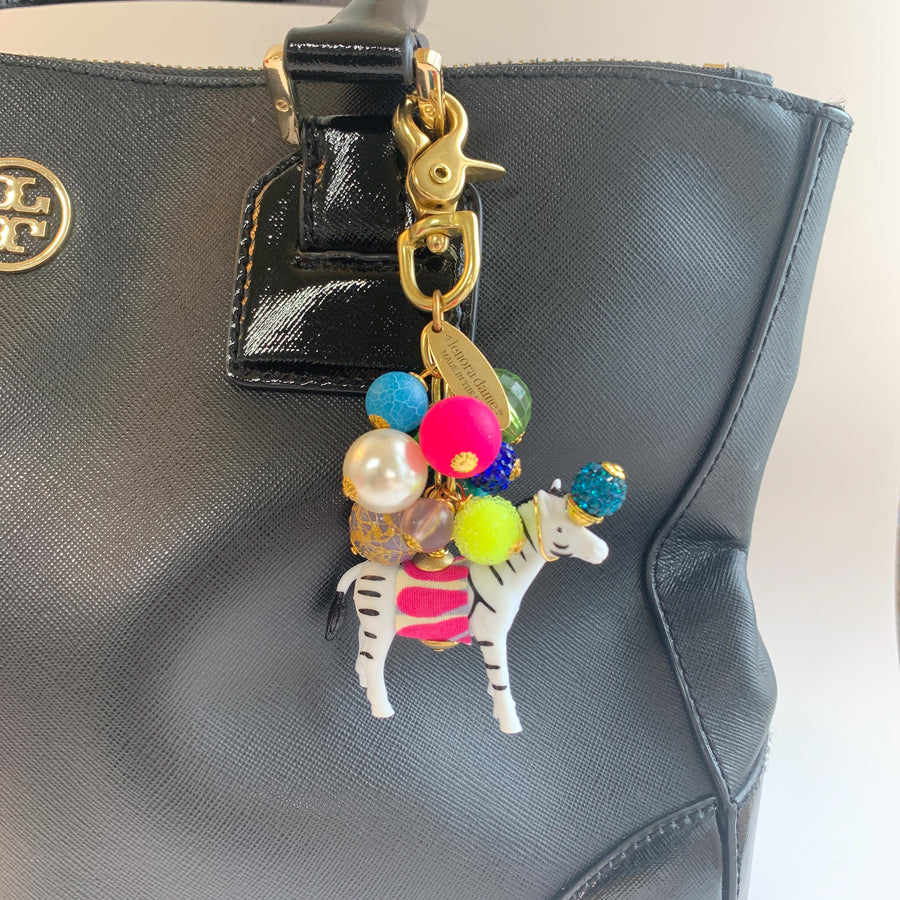 Colorful cute bag charm on a black handbag. Lenora Dame bag charms.