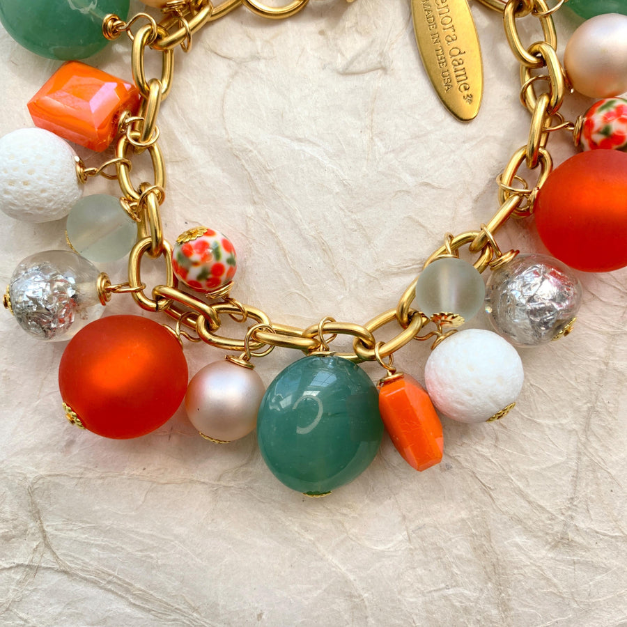 Lime green beads, orange beads, white beads, silver beads wire wrapped on a gold chain.
