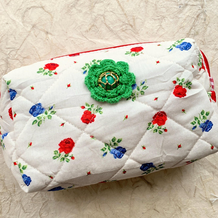 Red and blue flowers on white cotton fabric quilted zipper pouch embellished with a green crochet flower with a vintage earring center. Quilted makeup bag. Cute makeup bags with zipper. Gifts for mom.