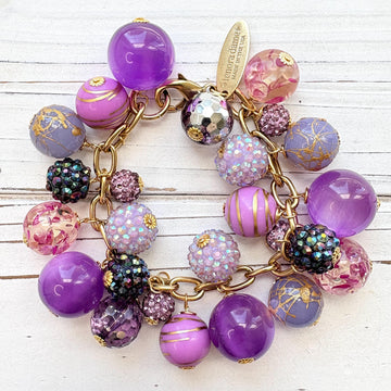Beaded purple bracelet with assorted mix of purple beads on a gold chain and a Lenora Dame hangtag. Purple chunky bracelet. Lenora Dame jewelry made in USA.
