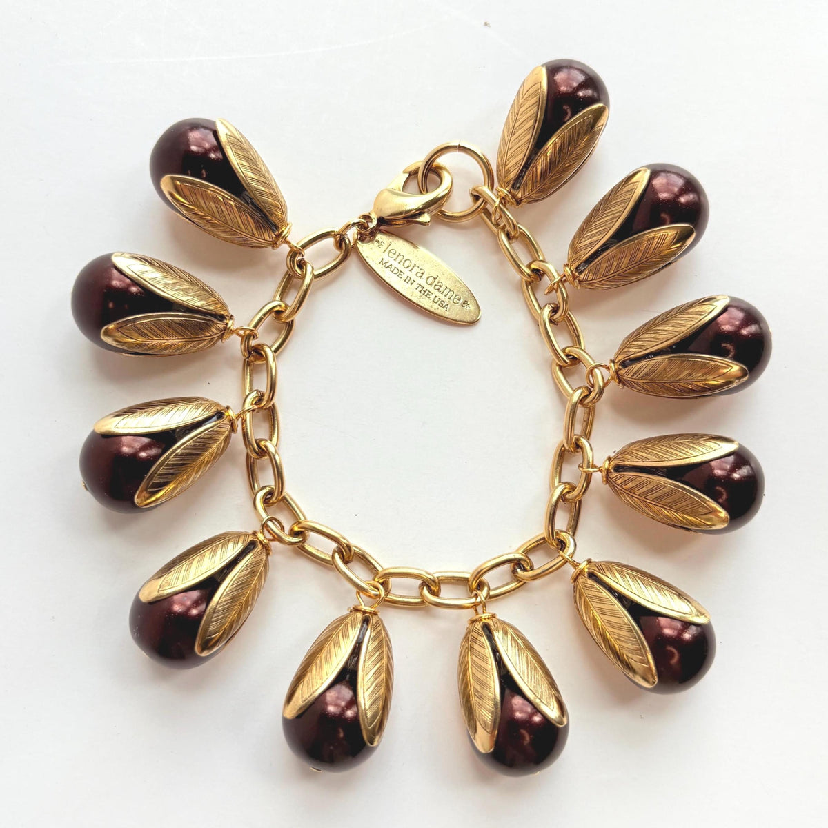 Gold chain bracelet with shiny brown pearls encased in gold leaf bead caps. Lenora Dame bracelets handmade in the USA.