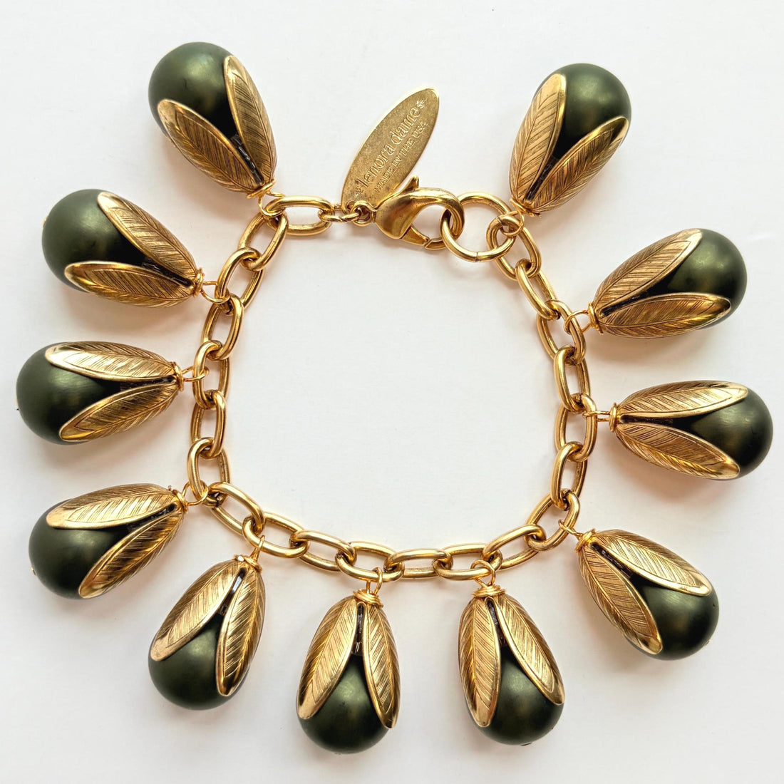 Gold chain bracelet with matte finish hunter green pearls encased in gold leaf bead caps. Lenora Dame bracelets handmade in the USA.