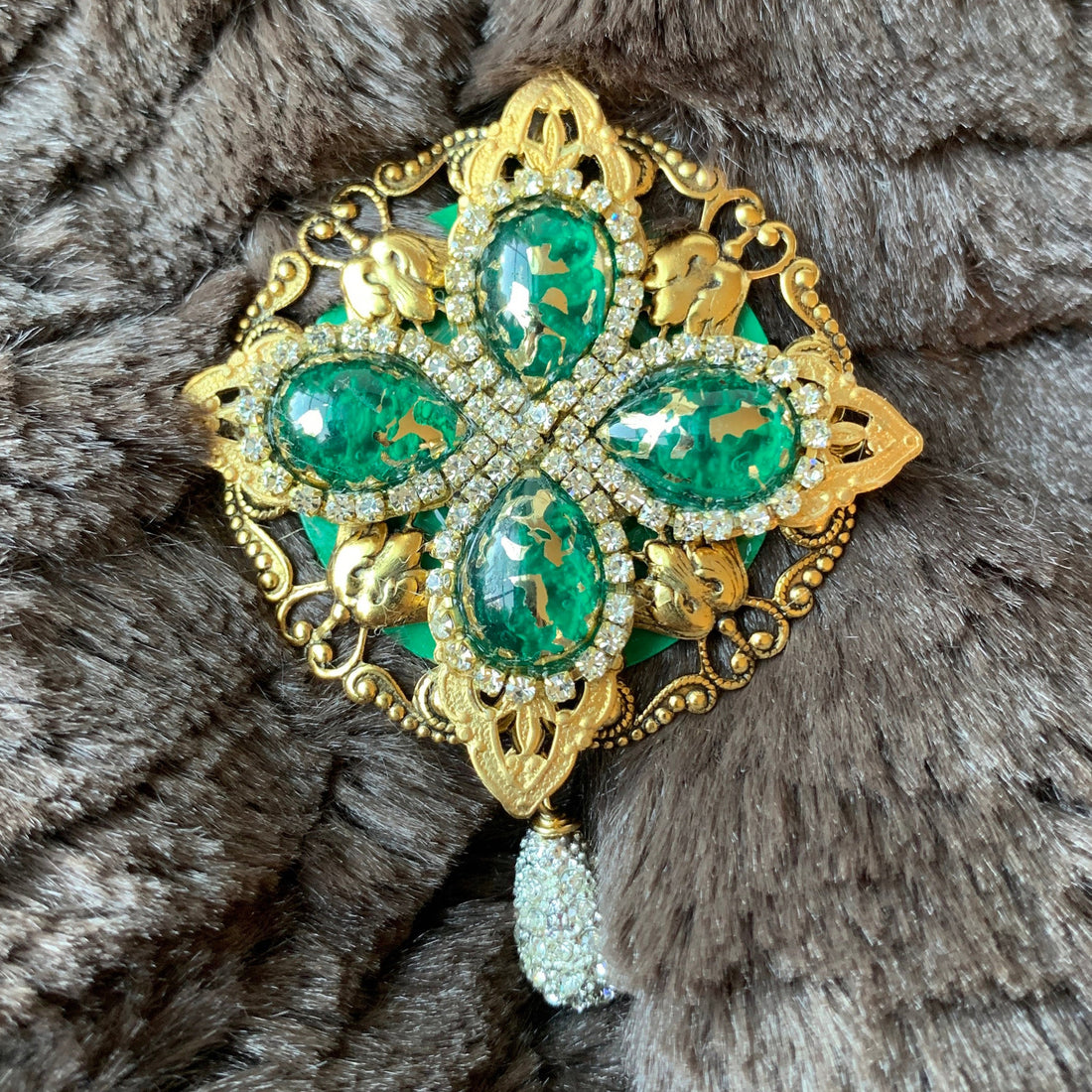 Gold rhinestone brooch with emerald green tear drop gemstones surrounded by crystal clear rhinestones. Vintage inspired lapel pin. 